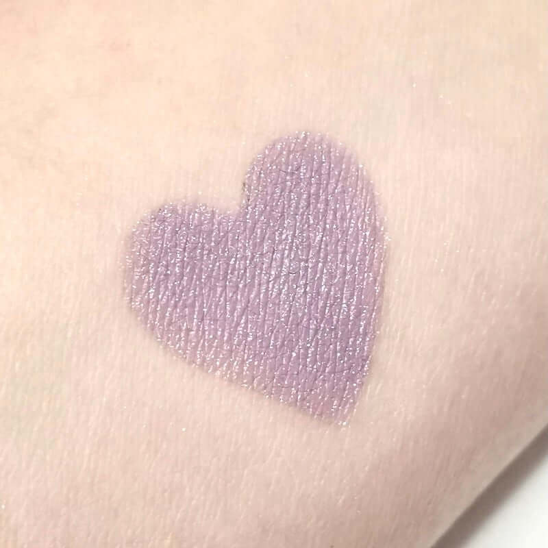 Zachtpaarse oogschaduw met zilveren glitter in een hartvorm op de huid, ideaal voor een romantische look.