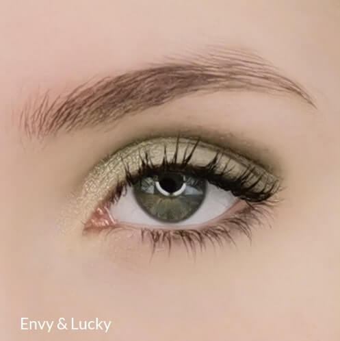 Model wearing lichte metallic groene oogschaduw Envy voor subtiele en uitgesproken ooglooks.