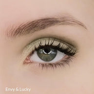 Model wearing lichte metallic groene oogschaduw Envy voor subtiele en uitgesproken ooglooks.