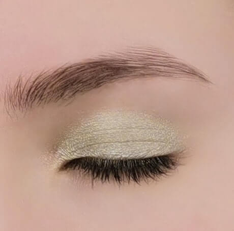 Close-up of an eye showcasing licht metallic groene oogschaduw Envy with a delicate shine.