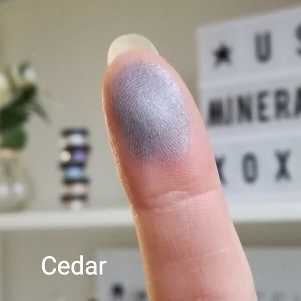 Swatch von Cedar mit grauem Schimmer auf der Fingerspitze
